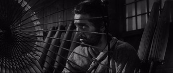 Movie still from “Harakiri” (1962), directed by Masaki Kobayashi – A black and white photo of a man behind bars; Close Up shot, Low angle