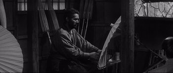 Movie still from “Harakiri” (1962), directed by Masaki Kobayashi – A black and white photo of a man holding an umbrella; Medium shot, Low angle