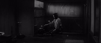 Movie still from “Harakiri” (1962), directed by Masaki Kobayashi – A man sitting on the ground with a bowl in front of him; Wide shot, High angle