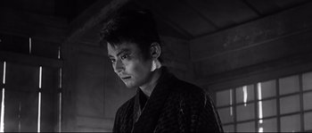 Movie still from “Harakiri” (1962), directed by Masaki Kobayashi – A man in a black robe standing in front of a wall; Close Up shot, Low angle