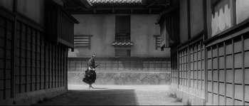 Movie still from “Harakiri” (1962), directed by Masaki Kobayashi – A man walking in the courtyard of an old house; Extreme Wide shot, Low angle