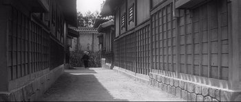 Movie still from “Harakiri” (1962), directed by Masaki Kobayashi – A person walking down a street near a building; Extreme Wide shot, Low angle