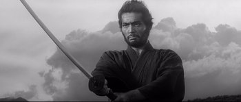Movie still from “Harakiri” (1962), directed by Masaki Kobayashi – Black and white photograph of a man holding a sword; Medium shot, Low angle
