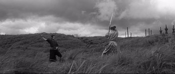 Movie still from “Harakiri” (1962), directed by Masaki Kobayashi – A man and a woman are in a field with a sword; Wide shot, Low angle