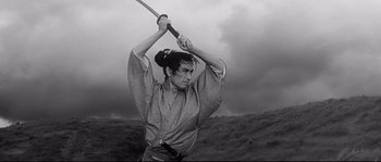 Movie still from “Harakiri” (1962), directed by Masaki Kobayashi – A woman holding a katana in her hands; Medium shot, Low angle