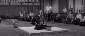 Movie still from “Harakiri” (1962), directed by Masaki Kobayashi – A group of people sitting on a mat in a room; Wide shot, High angle