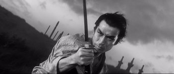 A black and white photo of a man holding a sword