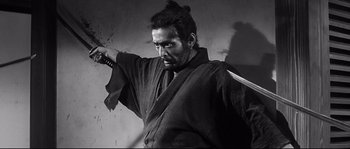 Movie still from “Harakiri” (1962), directed by Masaki Kobayashi – Black and white photograph of a man holding a sword; Close Up shot, Low angle