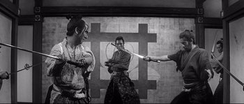 Movie still from “Harakiri” (1962), directed by Masaki Kobayashi – A group of people holding swords in front of a target; Medium shot, Over the shoulder angle