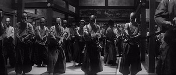 Movie still from “Harakiri” (1962), directed by Masaki Kobayashi – A black and white photo of a group of people in traditional garb; Wide shot, High angle