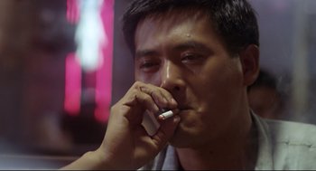 Movie still from “Hard Boiled” (1992), directed by John Woo – A person talking on a cell phone; Close Up shot, Low angle