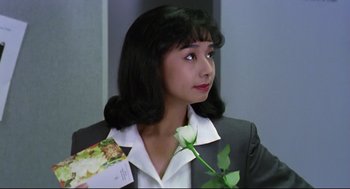 Movie still from “Hard Boiled” (1992), directed by John Woo – A woman holding a white rose in her hand; Close Up shot, High angle