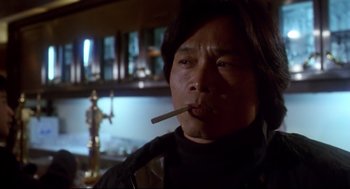 Movie still from “Hard Boiled” (1992), directed by John Woo – A man smoking a cigarette while wearing a black shirt; Close Up shot, Low angle