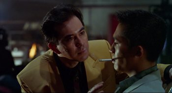 Movie still from “Hard Boiled” (1992), directed by John Woo – A man is smoking a cigarette while another man looks at him; Close Up shot, Over the shoulder angle