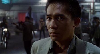 Movie still from “Hard Boiled” (1992), directed by John Woo – A person wearing a suit and tie; Close Up shot, Low angle