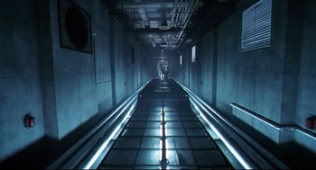 Movie still from “Hard Boiled” (1992), directed by John Woo – A dark hallway with a person walking on the sidewalk; Extreme Wide shot, Low angle