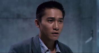 Movie still from “Hard Boiled” (1992), directed by John Woo – A person wearing a suit and tie; Close Up shot, High angle