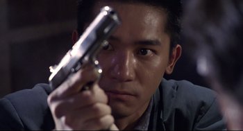 Movie still from “Hard Boiled” (1992), directed by John Woo – A person holding a gun; Close Up shot, Low angle