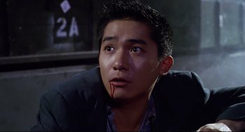 Movie still from “Hard Boiled” (1992), directed by John Woo – A person with blood on his face; Close Up shot, High angle
