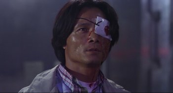 Movie still from “Hard Boiled” (1992), directed by John Woo – A man with a bandage on his eye; Close Up shot, Low angle