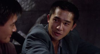 Movie still from “Hard Boiled” (1992), directed by John Woo – A person wearing a suit and tie; Close Up shot, Over the shoulder angle