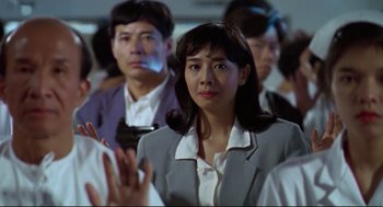 Movie still from “Hard Boiled” (1992), directed by John Woo – A group of people sitting in a room; Close Up shot, Over the shoulder angle