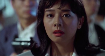 Movie still from “Hard Boiled” (1992), directed by John Woo – A person with a cell phone; Close Up shot, Low angle