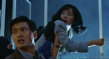 Movie still from “Hard Boiled” (1992), directed by John Woo – A woman holding a man's hand while standing in front of a mirror; Medium shot, Low angle