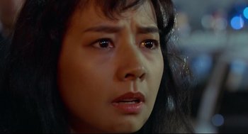 Movie still from “Hard Boiled” (1992), directed by John Woo – A woman's face looking sad; Close Up shot, High angle