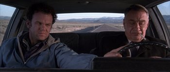 Movie still from “Hard Eight” (1996), directed by Paul Thomas Anderson – A man sitting in the back seat of a car; Medium shot, Over the shoulder angle