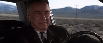 Movie still from “Hard Eight” (1996), directed by Paul Thomas Anderson – A man in a suit and tie driving a car; Close Up shot, Low angle