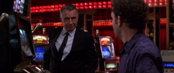 Movie still from “Hard Eight” (1996), directed by Paul Thomas Anderson – A man wearing a suit and tie talking to another man in a suit; Medium shot, Over the shoulder angle