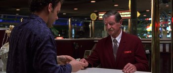 Movie still from “Hard Eight” (1996), directed by Paul Thomas Anderson – An older man in a red jacket is giving a young man a piece of paper; Medium shot, Low angle