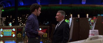 Movie still from “Hard Eight” (1996), directed by Paul Thomas Anderson – A man in a suit and tie standing next to another man in a suit; Medium shot, Over the shoulder angle