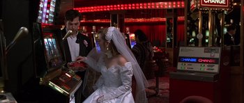 Movie still from “Hard Eight” (1996), directed by Paul Thomas Anderson – A woman in a wedding dress and a man in a black suit; Medium shot, Over the shoulder angle