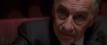 Movie still from “Hard Eight” (1996), directed by Paul Thomas Anderson – An older man in a suit and tie looking at the camera; Close Up shot, Low angle