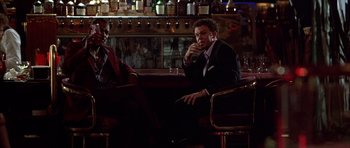Movie still from “Hard Eight” (1996), directed by Paul Thomas Anderson – Two men in suits sitting in front of a bar; Medium shot, Low angle