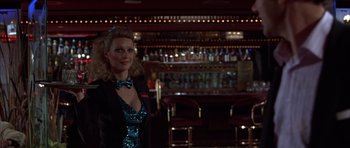 Movie still from “Hard Eight” (1996), directed by Paul Thomas Anderson – A woman standing in front of a bar wearing a blue dress; Medium shot, Over the shoulder angle