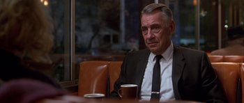 Movie still from “Hard Eight” (1996), directed by Paul Thomas Anderson – An older man sitting at a table with a cup of coffee in front of him; Close Up shot, Over the shoulder angle