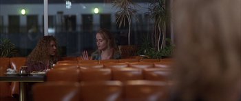 Movie still from “Hard Eight” (1996), directed by Paul Thomas Anderson – A woman sitting at a table in front of a window; Medium shot, High angle