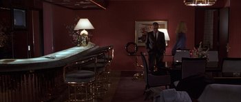 Movie still from “Hard Eight” (1996), directed by Paul Thomas Anderson – A man in a suit standing in front of a table; Wide shot, High angle