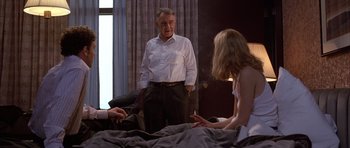 Movie still from “Hard Eight” (1996), directed by Paul Thomas Anderson – A man standing next to two women in a bed; Medium shot, Over the shoulder angle