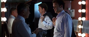 Movie still from “Hard Eight” (1996), directed by Paul Thomas Anderson – A group of men standing next to each other in a room; Medium shot, Over the shoulder angle