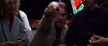 Movie still from “Hard Eight” (1996), directed by Paul Thomas Anderson – A man holding a red pill in his hand; Close Up shot, High angle