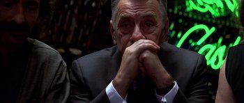 Movie still from “Hard Eight” (1996), directed by Paul Thomas Anderson – An older man wearing a suit and white shirt; Close Up shot, Low angle