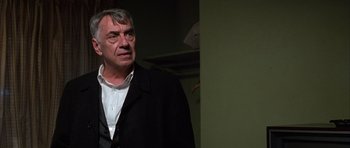 Movie still from “Hard Eight” (1996), directed by Paul Thomas Anderson – An older man wearing a black jacket and white shirt; Close Up shot, Over the shoulder angle