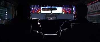 Movie still from “Hard Eight” (1996), directed by Paul Thomas Anderson – A man sitting in the back seat of a car at night; Medium shot, Over the shoulder angle