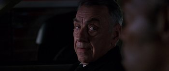 Movie still from “Hard Eight” (1996), directed by Paul Thomas Anderson – An older man in a black suit looking at the camera; Close Up shot, Over the shoulder angle