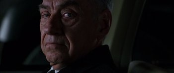 Movie still from “Hard Eight” (1996), directed by Paul Thomas Anderson – An older man wearing a suit and tie looking at the camera; Close Up shot, Low angle