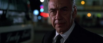 Movie still from “Hard Eight” (1996), directed by Paul Thomas Anderson – An older man wearing a suit and tie in front of lights; Close Up shot, Low angle